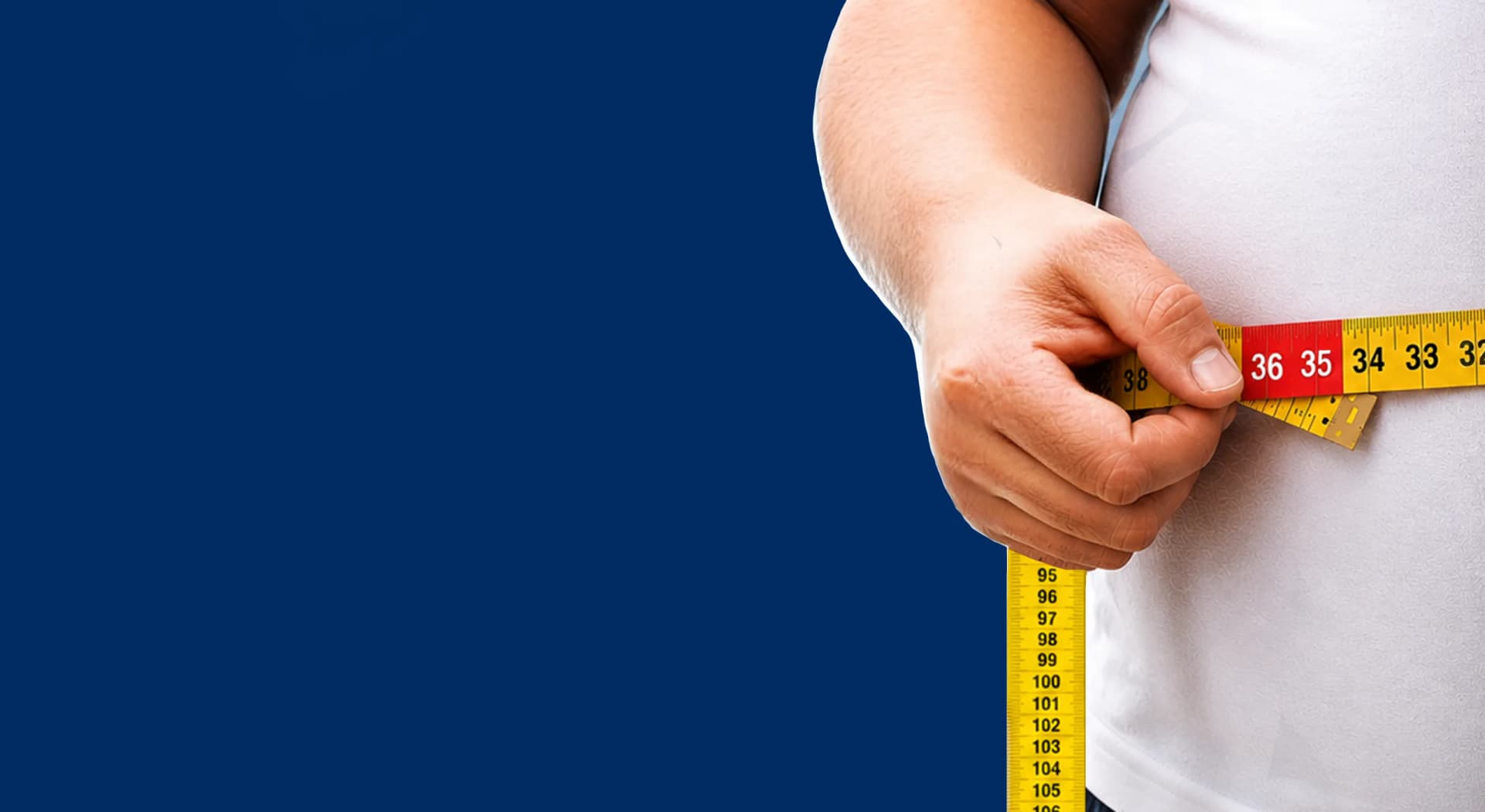 A man measuring his waist with a tape measure